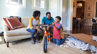Male and female giving a new bike to their son