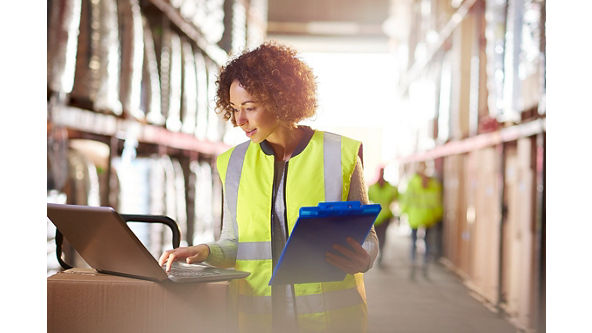 Women in logistics looking at a computer with a clipboard