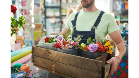 man holding a crate of flowers