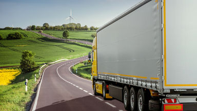 Semi-truck going up a winding road in the countryside 