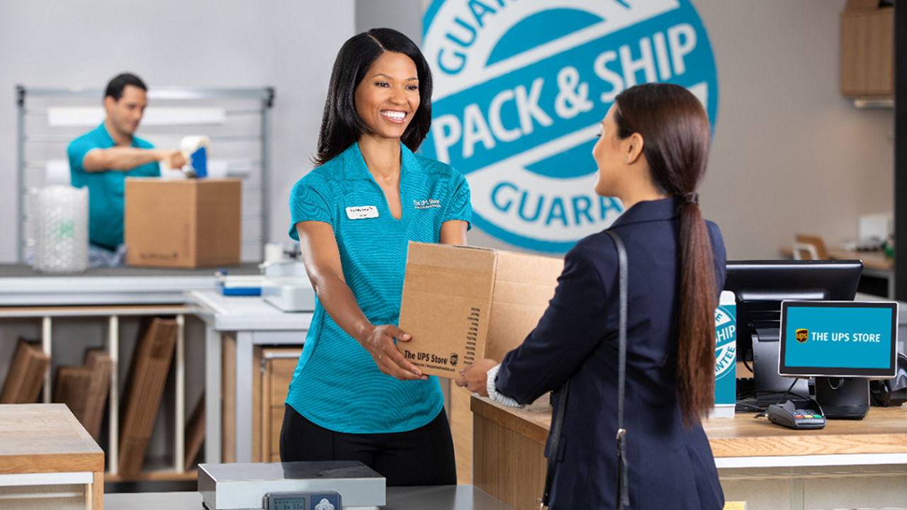 TUPPS associate handing box to customer