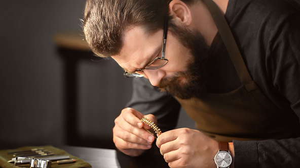 Male jeweler inspecting a gold and diamond bracelet