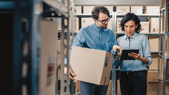 two people holding a box and looking at an ipad