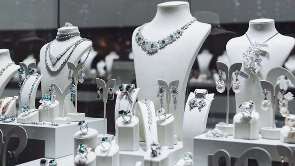Jewelry store display with silver and green earrings, rings, and necklaces 