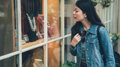 Female looking a jewelry through a window 