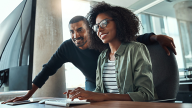 Two people looking at computer monitor