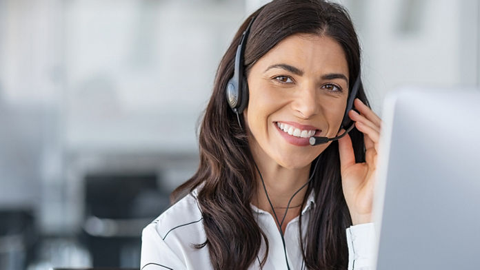 Female wearing a headset while holding the microphone in an office