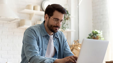 Male using his laptop in a kitchen 