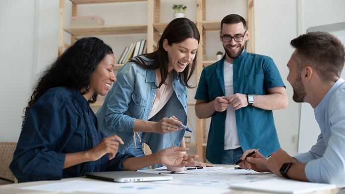 Group of people looking at papers and working together in an office