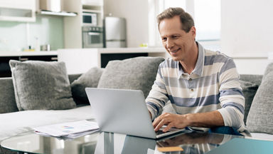 Male sitting on a couch and using a laptop