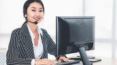 Female service representative wearing a headset and using a computer 