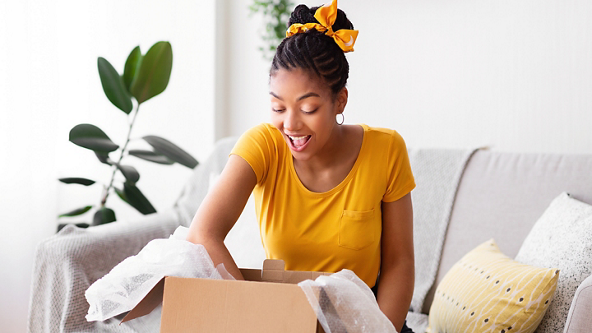 Female sitting on a couch with her hand in an open box