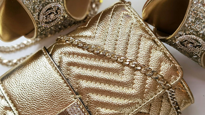 Close up of a gold bag and shoes