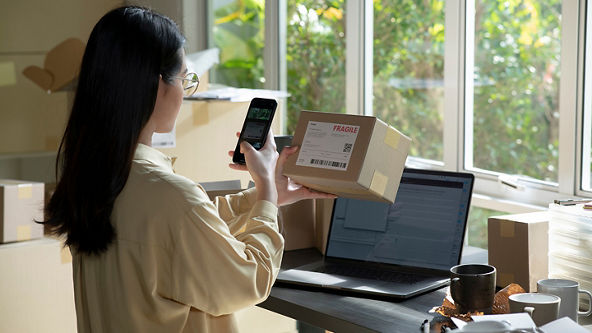 Woman scanning a label on a box with her phone