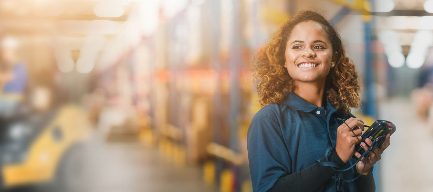 Female in a warehouse using a hand held device