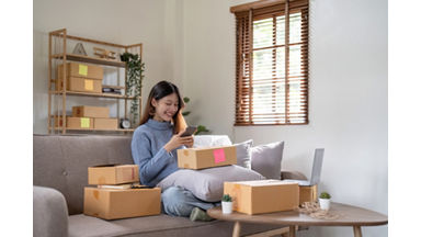 Startup small business entrepreneur SME freelance woman work with smart phone, Young Asian small business owner use computer, online market packing box delivery, SME e-commerce telemarketing concept; Shutterstock ID 2231757839; purchase_order: Delivery Defense; job: ; client: ; other: 