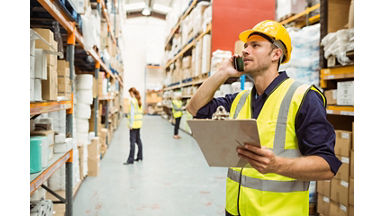 Warehouse worker talking on the phone holding clipboard in a large warehouse; Shutterstock ID 252244078; purchase_order: Channel Partner; job: ; client: ; other: 