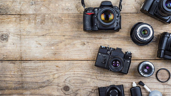 Overhead view of multiple cameras on a wooden background