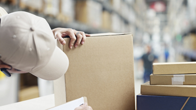 Male looking at a box and holding clip board