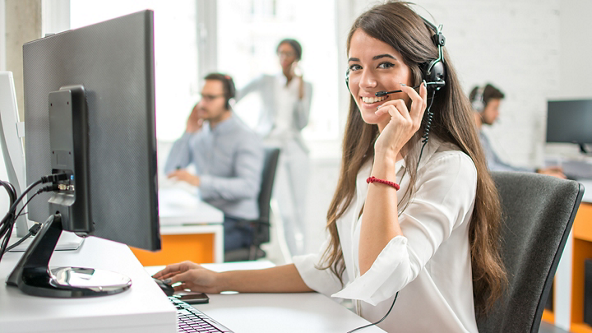 Female wearing a headset while holding the microphone in an office