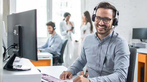 Male wearing a headset working in an office
